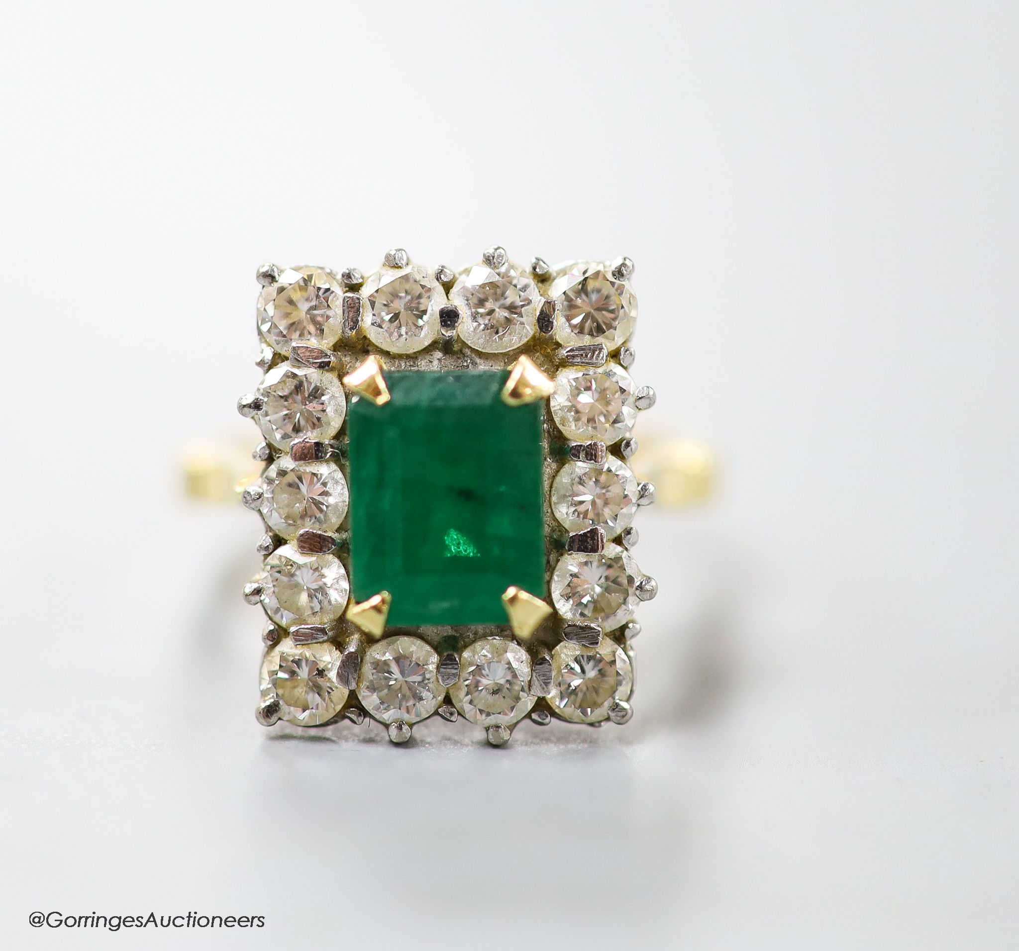 A modern 18ct gold, emerald and diamond set rectangular cluster ring, size K